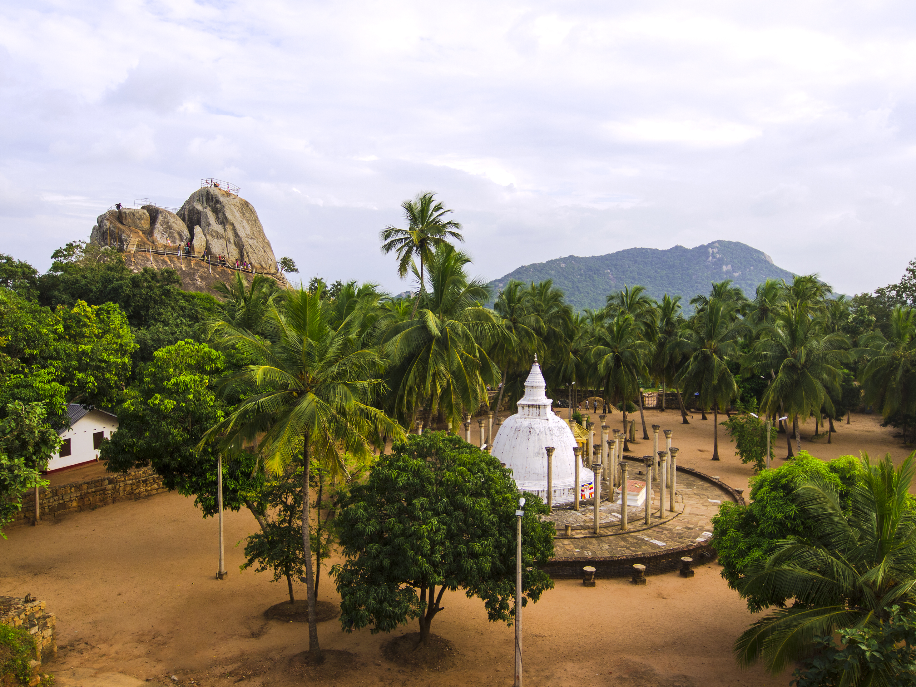 Mihintale mountain top sacred site in the Cultural Triangle, white bell shaped structure, trees, mountains
