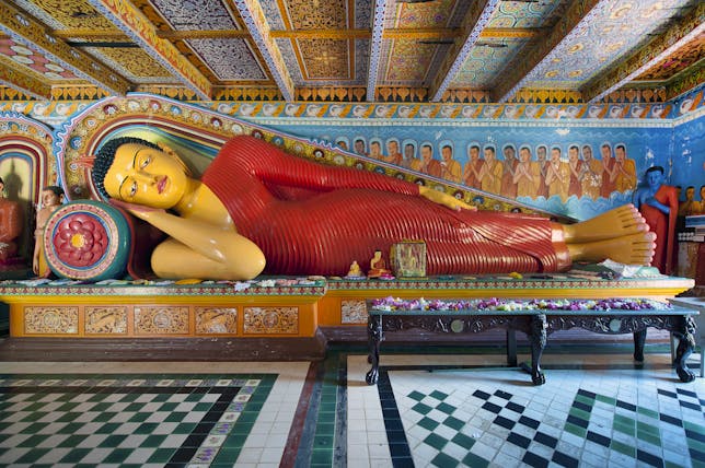Reclining Buddha at Isurumuniya Temple, intricate colourful carving, colourful room