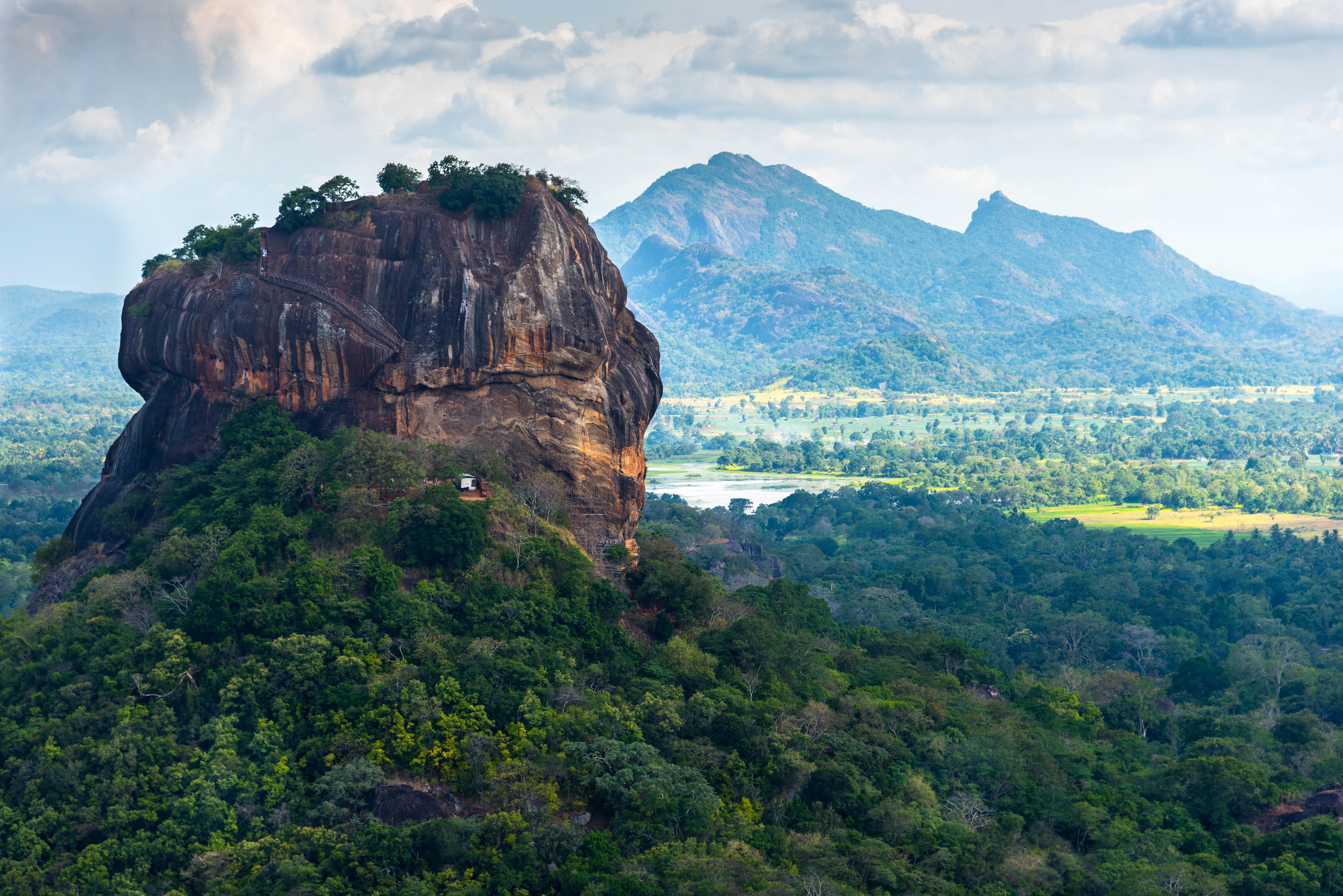 Sigiriya rock, sprawling landscape, mountains in background