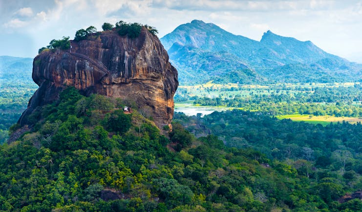 Sigiriya rock, sprawling landscape, mountains in background