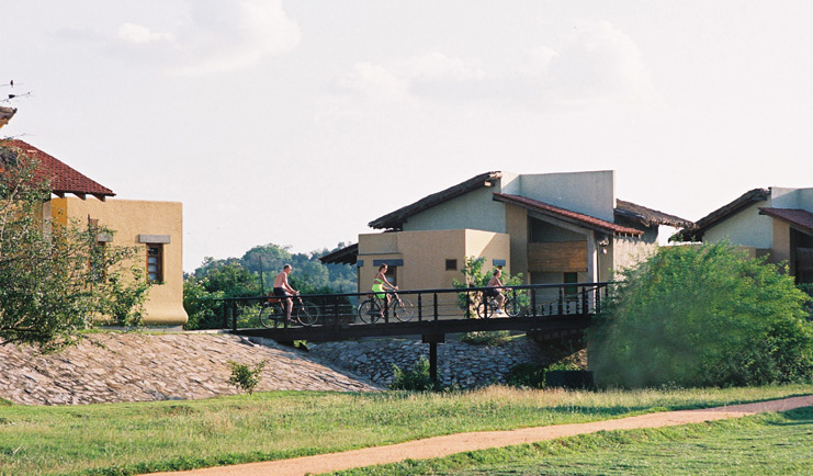 The Elephant Corridor Sri Lanka family cycling in front of hotel across bridge