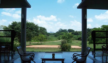 The Elephant Corridor Sri Lanka patio with two chairs and view of gardens with trees