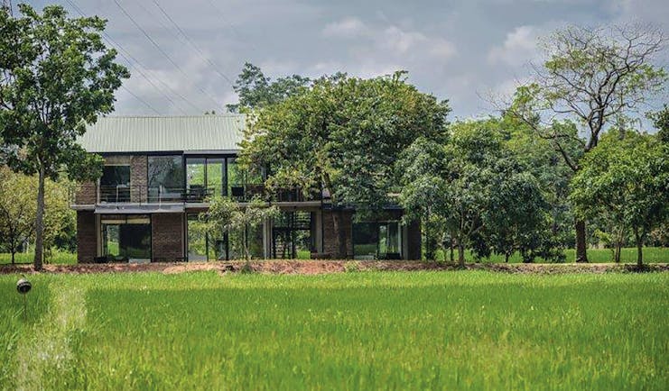 Kalundewa Retreat damunu chaler exterior, modern architecture, large lass windows, building surrounded by grass and trees
