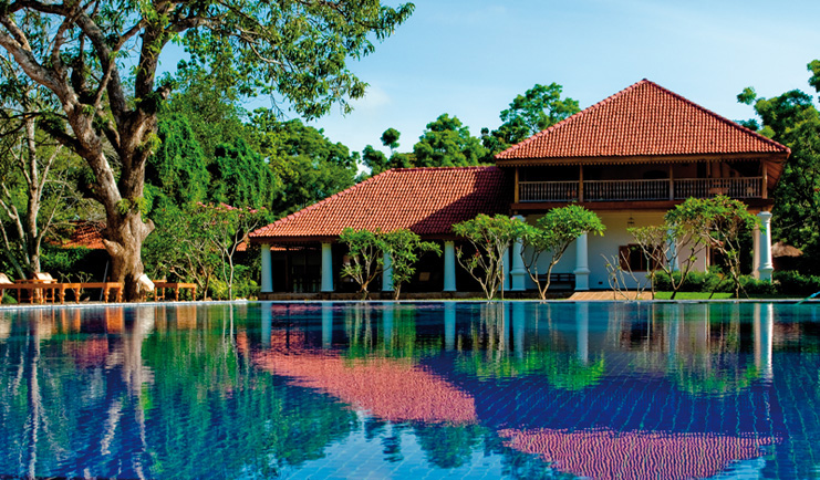 Ulagalla Resort outdoor pool outdoor terrace umbrellas and hotel building