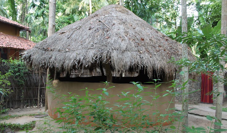 Ulpotha Sri Lanka mud hut wooden thatched roof trees