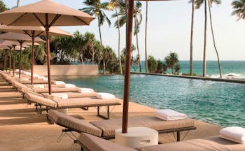 Amanwella Sri Lanka outdoor pool sun loungers umbrellas ocean view