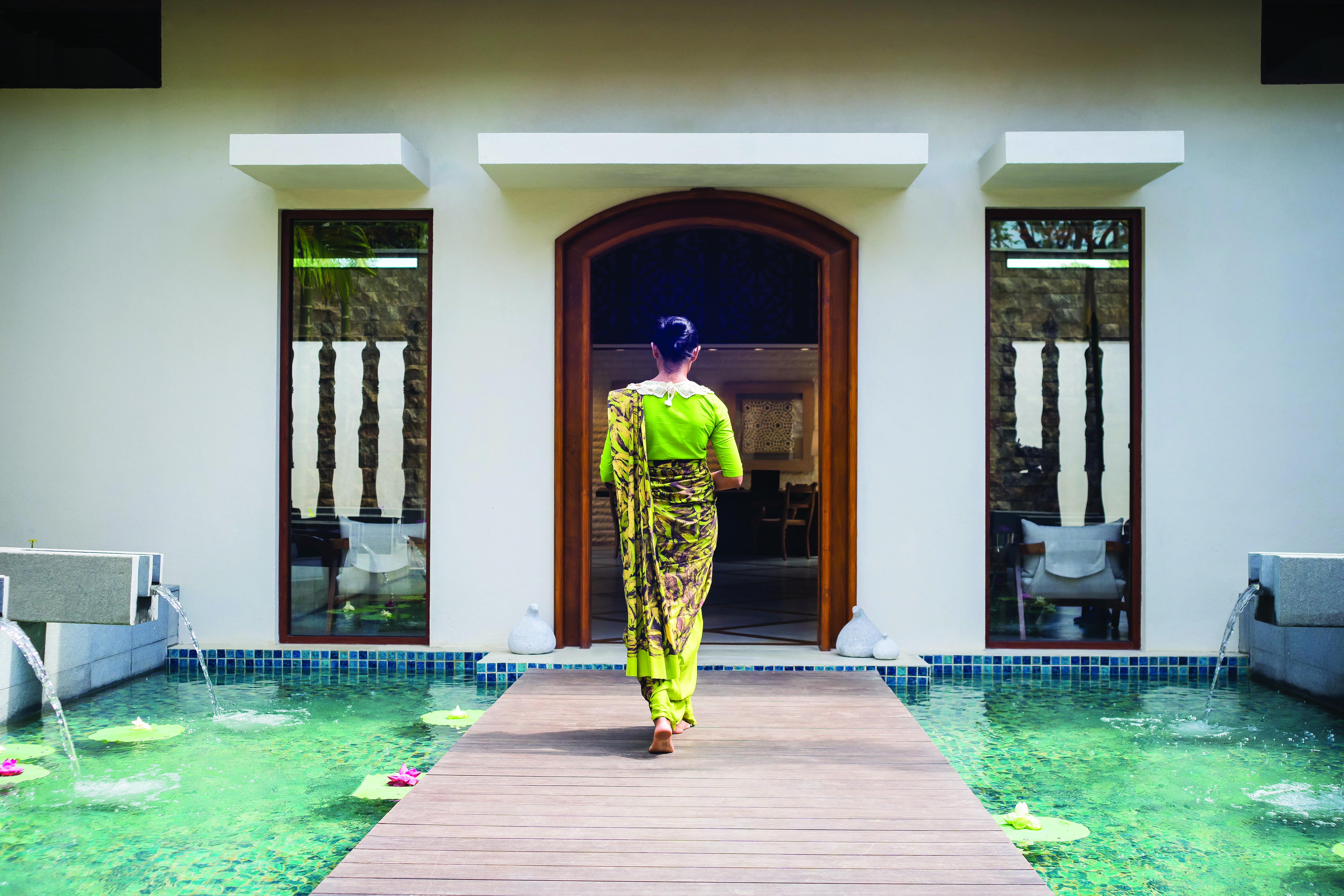 Anantara Peace Haven Tangalle Sri Lanka spa entrance walkway over water feature woman