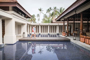 Anantara Peace Haven Tangalle Sri Lanka couple on walkway over water between lobby and spa