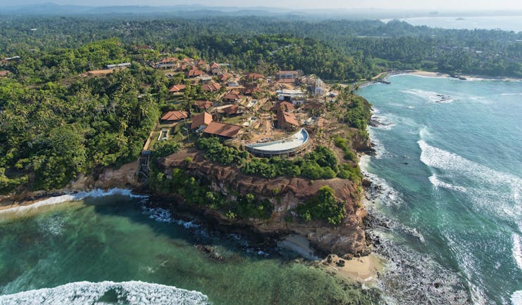 Aerial view of hotel and coastal area shown on the edge of a cliff