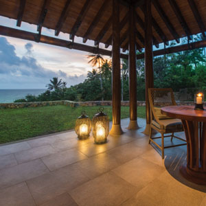Patio with lanterns, lawn and palm trees