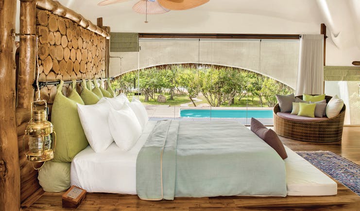 Chena Huts cabin bedroom, double bed, mesh walls overlooking pool, bright well-lit space