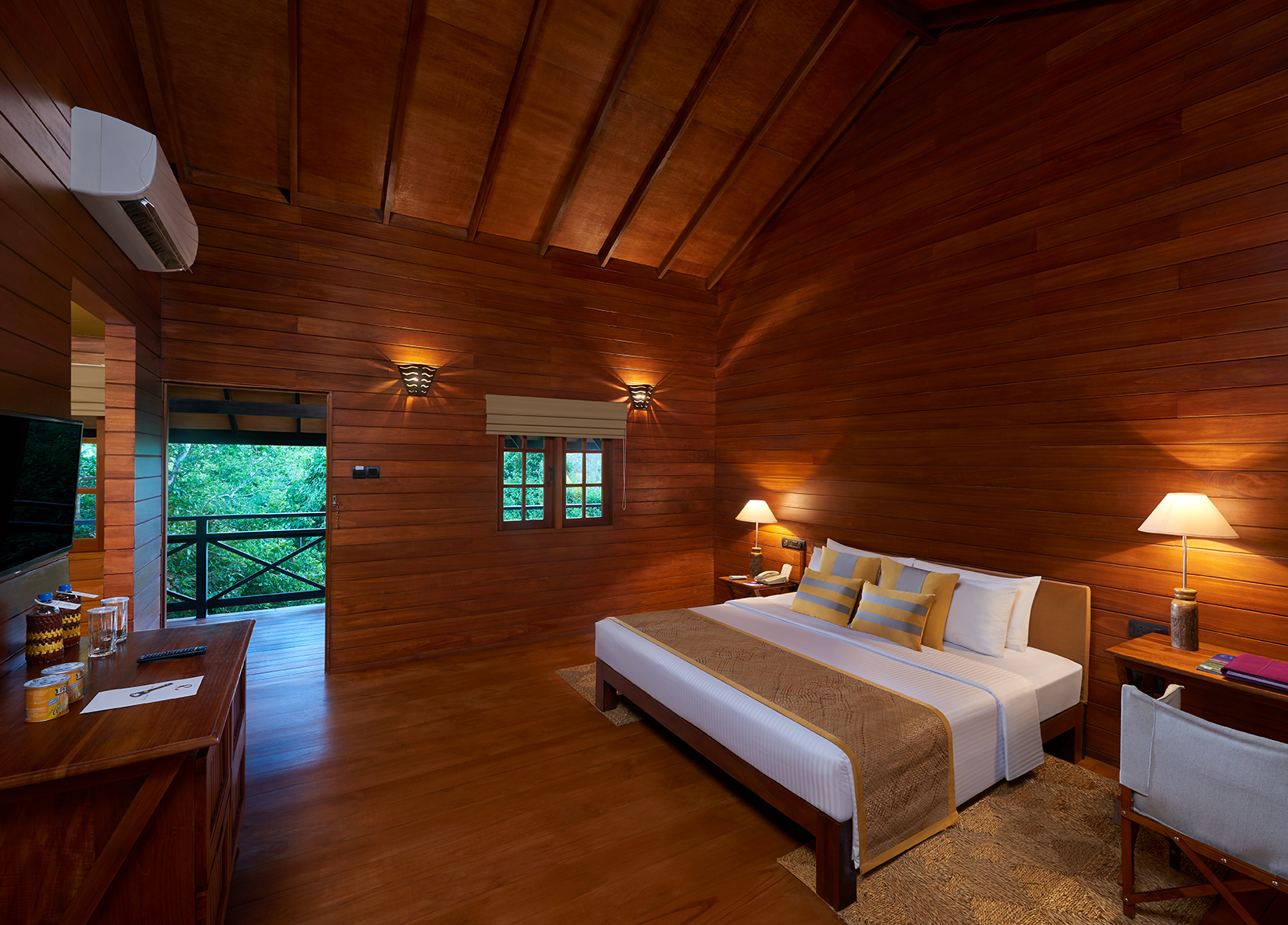 Cinnamon Wild beach chalet, double bed, dresser, wooden walls and ceiling, balcony with tree views