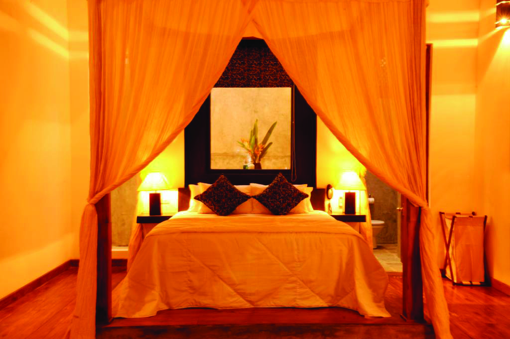 Era Beach Hotel guestroom, canopied bed, bright modern decor