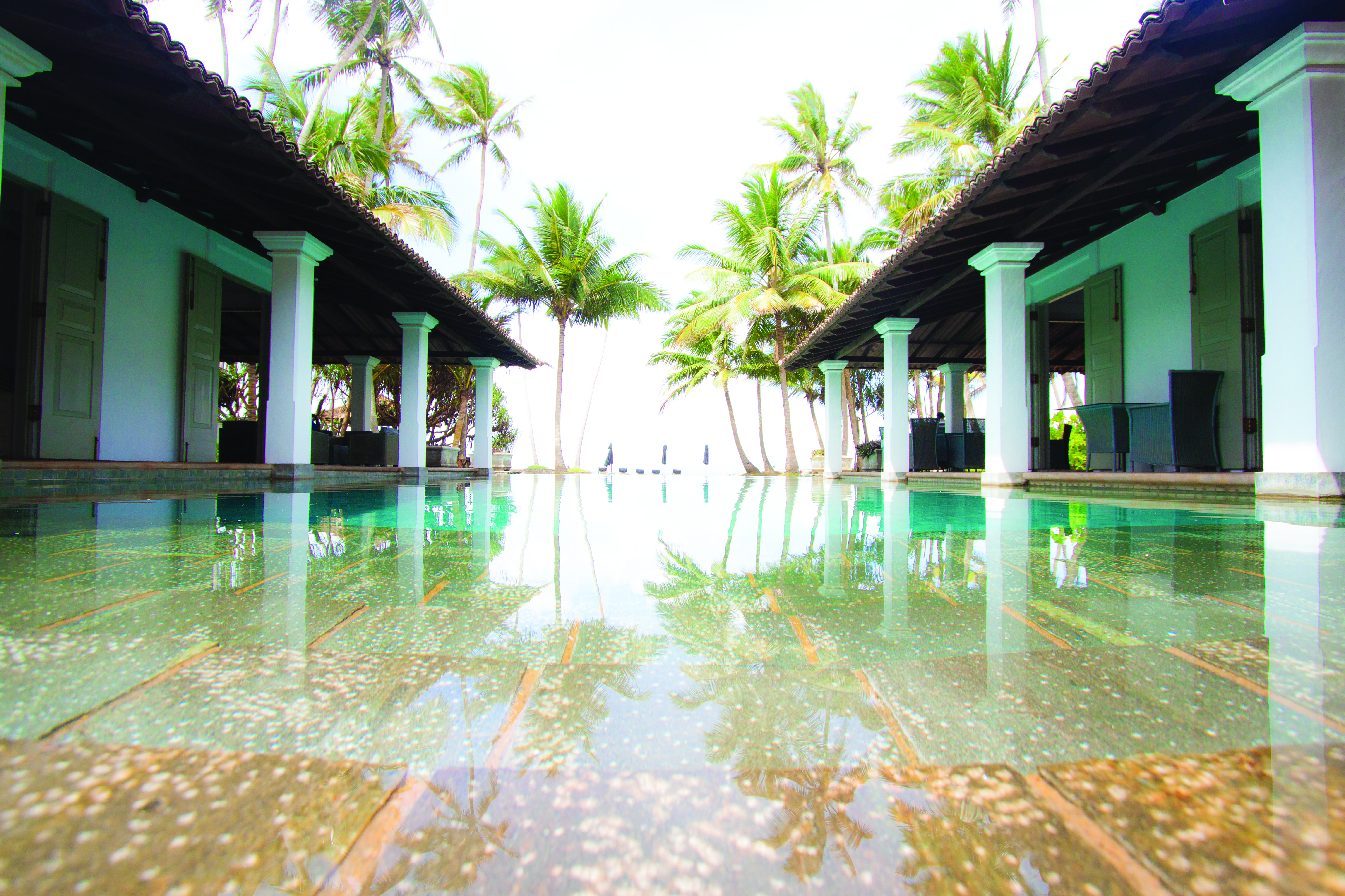 Era Beach Hotel pool, surrounded by columns, palm trees in background