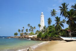 Dondra lighthouse on the South Coast, white lighthouse, palm trees, sand, ocean