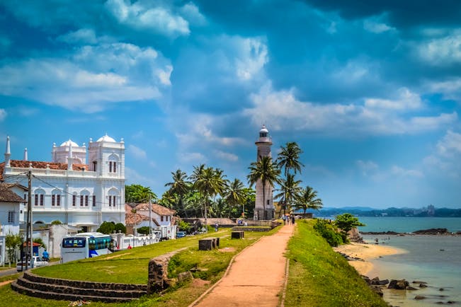 Lighthouse on the seafront in Galle, beach, waves, islands in backgrounds