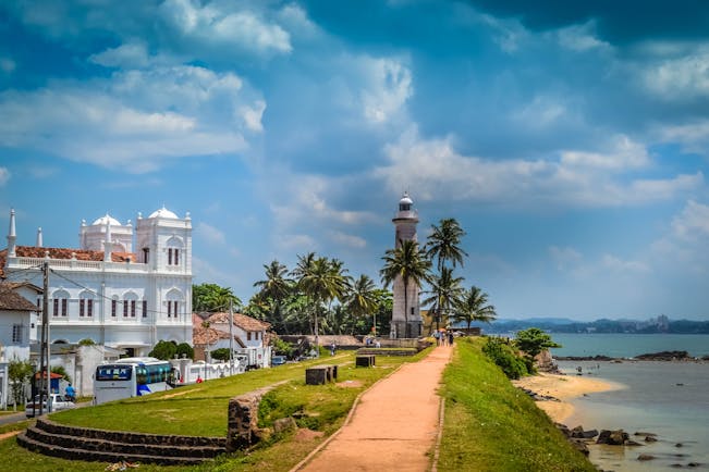 Lighthouse on the seafront in Galle, beach, waves, islands in backgrounds