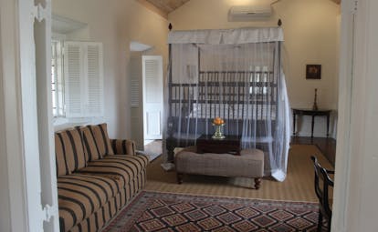Galle Fort Hotel grand apartment bedroom, canopied bed, foot stall, sofa
