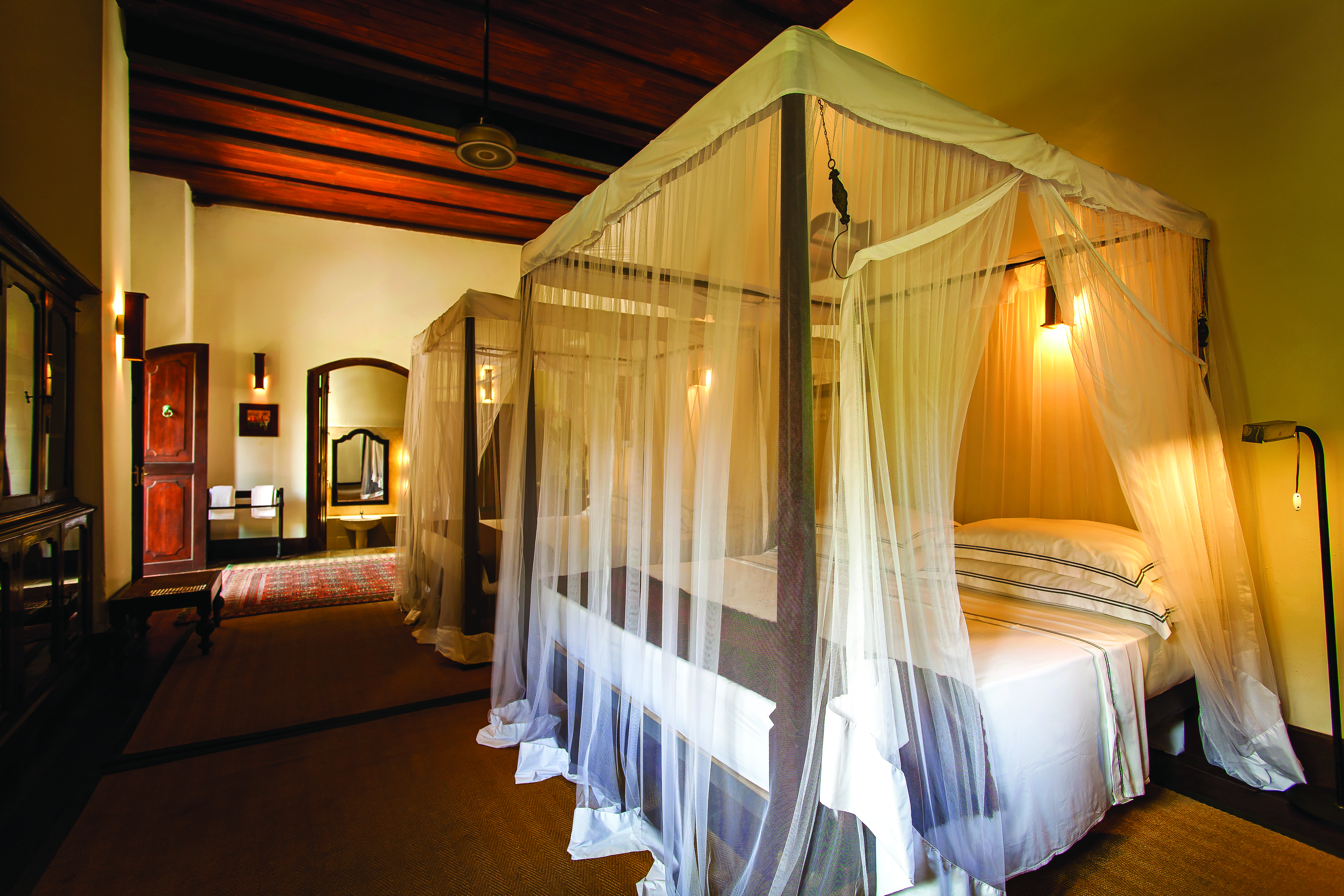 Galle Fort Hotel library suite, canopied bed, elegant minimal decor