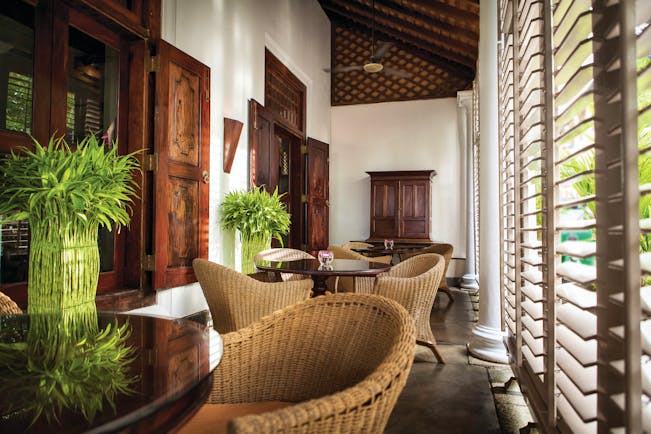 Galle Fort Hotel verandah, indoor sitting area, wicker tables and chairs, colonial style decor