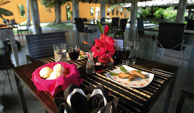 Kahanda Kanda Sri Lanka dining table with plates of food and glasses of wine