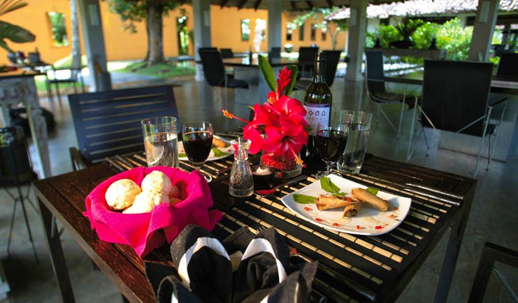 Kahanda Kanda Sri Lanka dining table with plates of food and glasses of wine