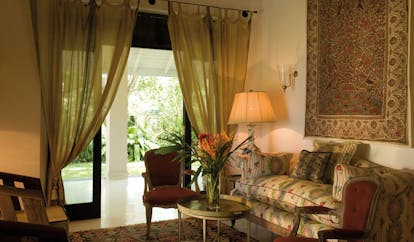 Kahanda Kanda Sri Lanka garden suite lounge area with traditional sofa and rug on wall