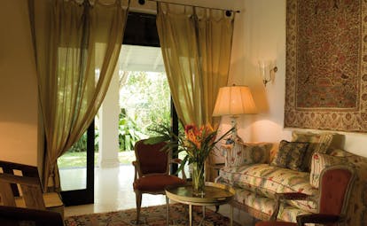 Kahanda Kanda Sri Lanka garden suite lounge area with traditional sofa and rug on wall