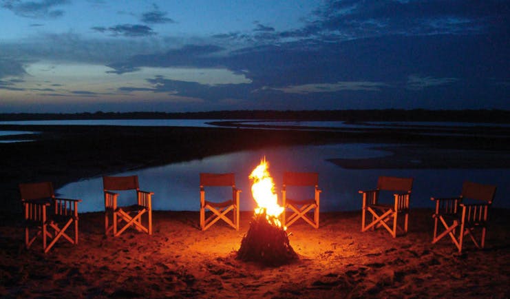 Mahoora Luxury Safari Camps Sri Lanka campfire chairs lake in background