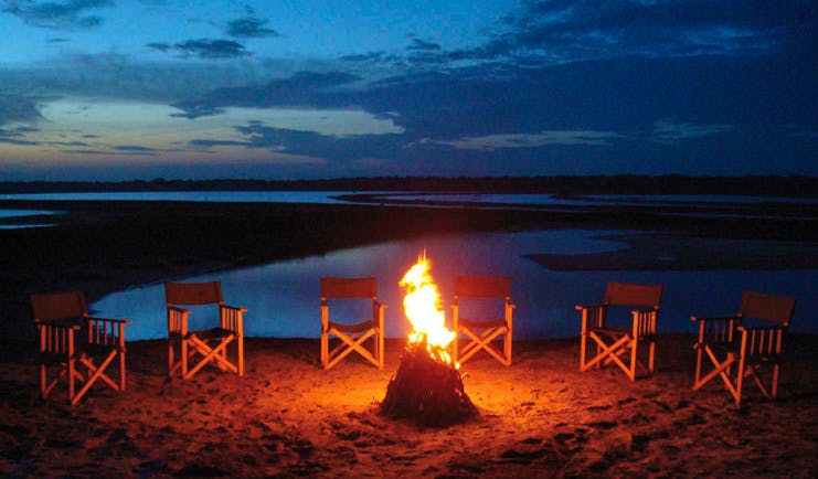 Mahoora Luxury Safari Camps Sri Lanka campfire chairs lake in background