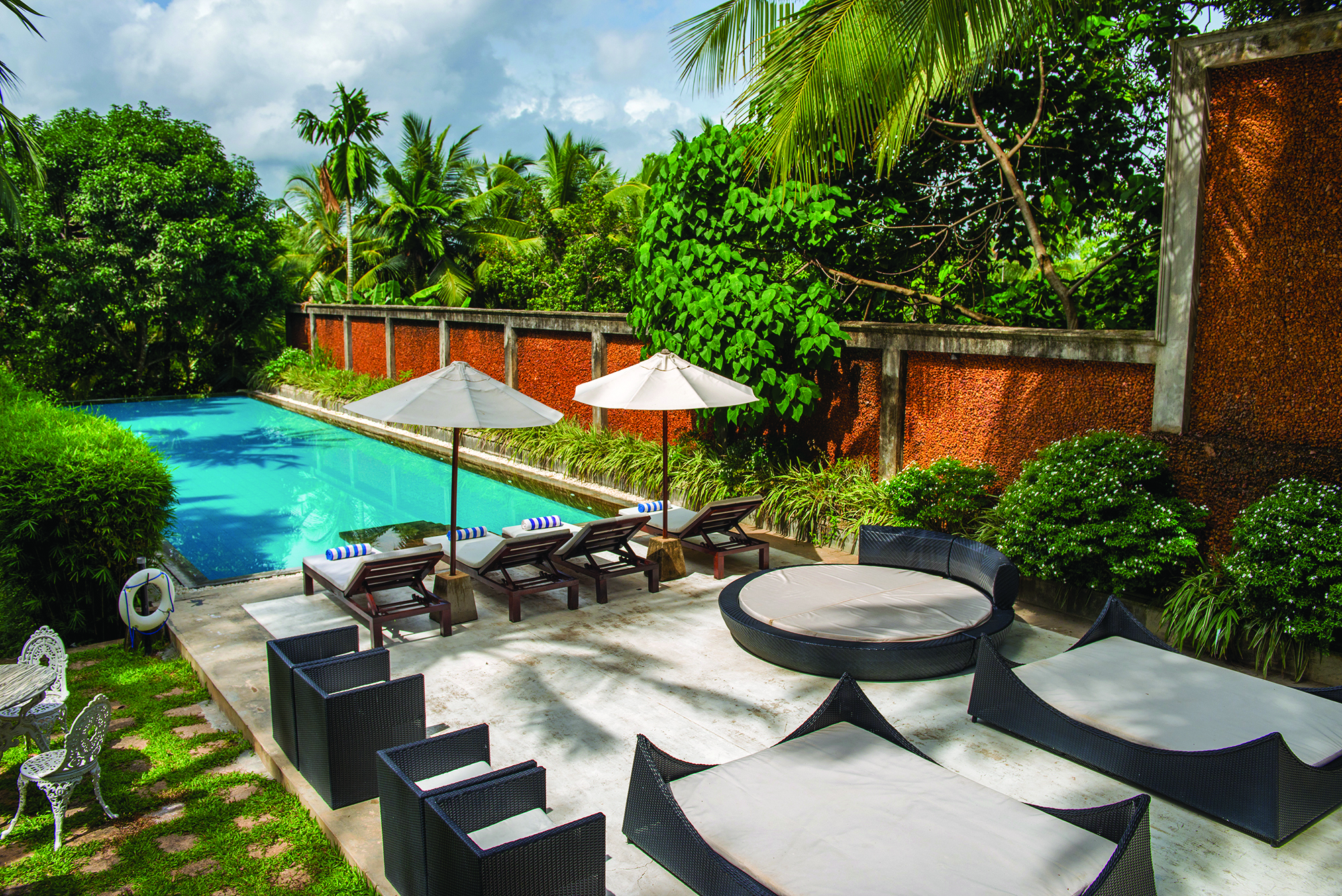 Tamarind Hill Sri Lanka pool sun loungers umbrellas patio greenery