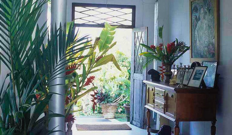 Taprobane Island Sri Lanka entrance porch dresser with antiques paintings and tropical flowers