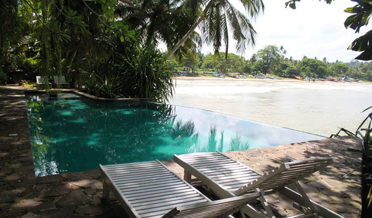 Taprobane Island Sri Lanka outdoor pool trees loungers next to beach 