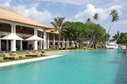 Outdoor swimming pool with palm trees and sun loungers