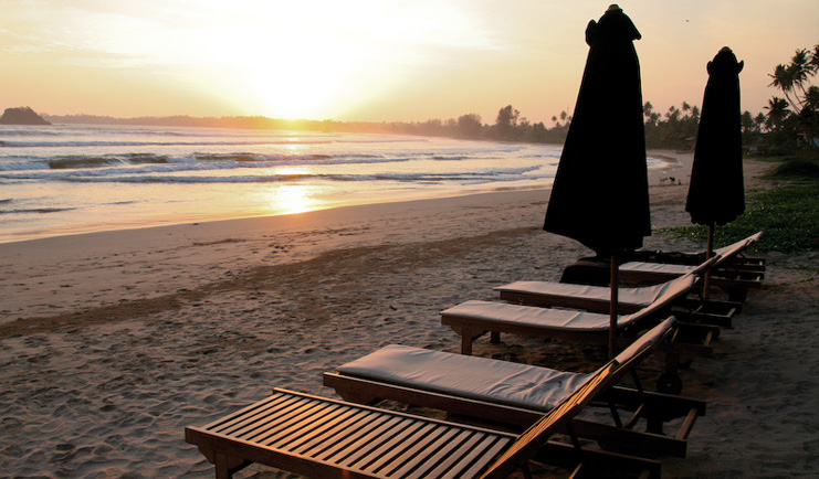Weligama Bay Resort Sri Lanka beach sunset sun loungers on beach with palms