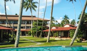 Weligama Bay Resort Sri Lanka outdoor pool with palm trees and view of bungalows and hotel