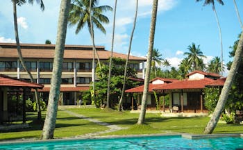 Weligama Bay Resort Sri Lanka outdoor pool with palm trees and view of bungalows and hotel