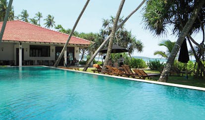 Weligama Bay Resort Sri Lanka poolside with loungers and sea view