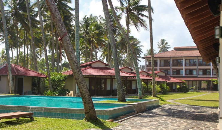 Weligama Bay Resort Sri Lanka villa pool outdoor pools with palm trees and bungalows