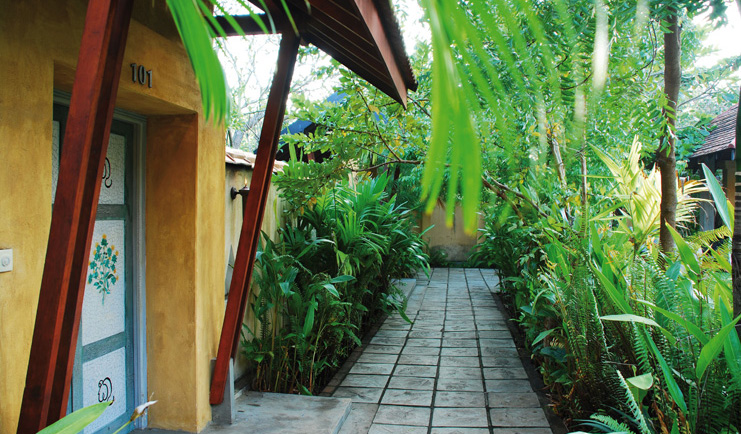 Ayurveda Pavilions Sri Lanka exterior yellow building painted doors stone path greenery