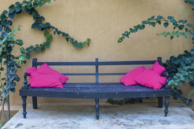 Casa Heliconia Sri Lanka bench outdoor seating area pink cushions green leaves