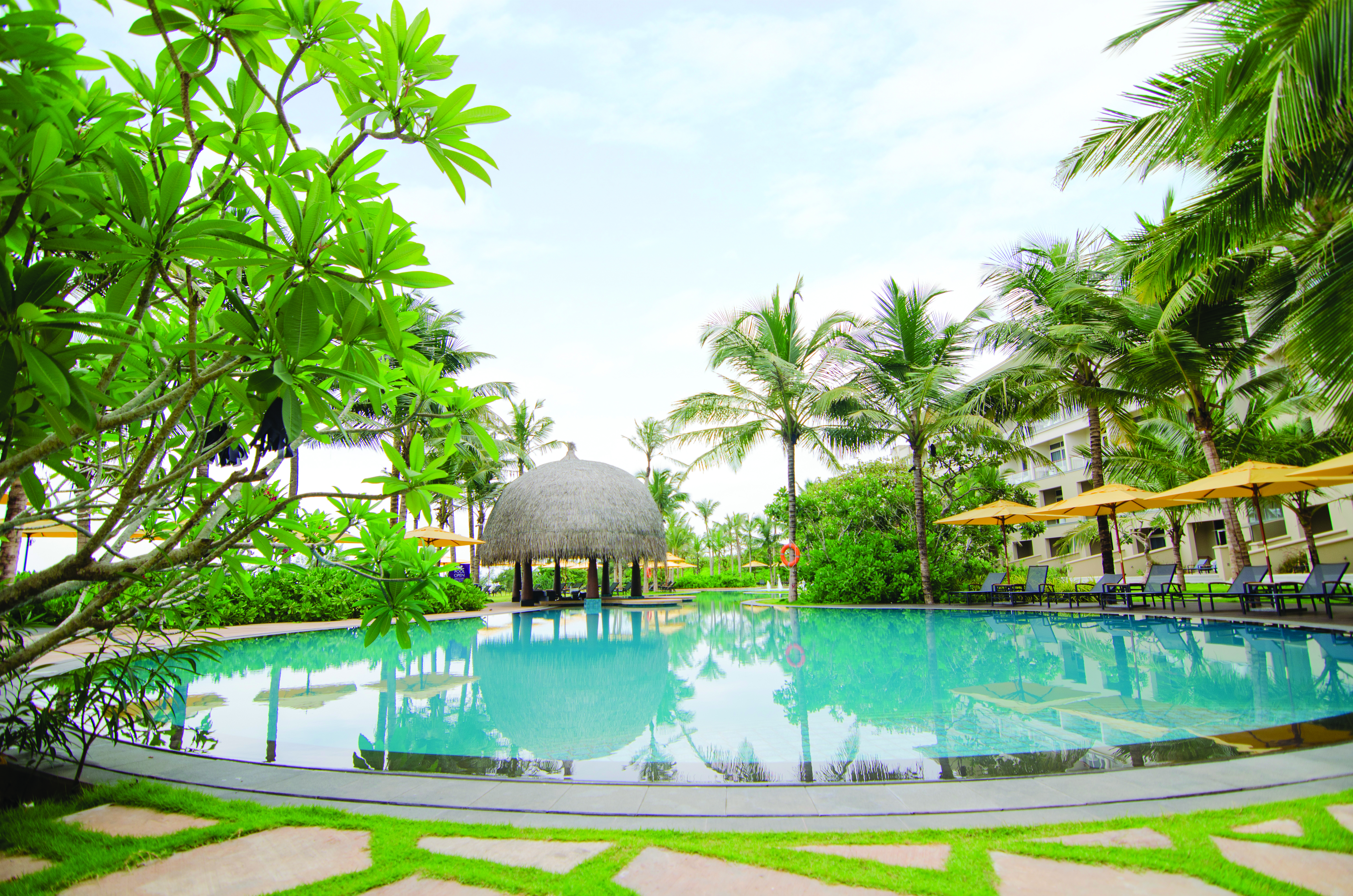 Heritance Negombo Sri Lanka pool umbrellas sun loungers trees hotel in background
