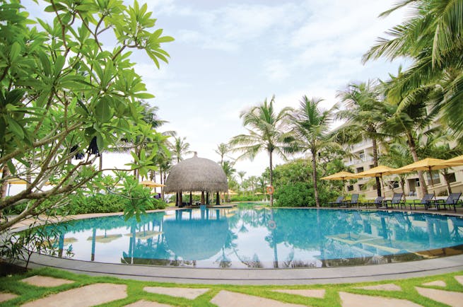 Heritance Negombo Sri Lanka pool umbrellas sun loungers trees hotel in background