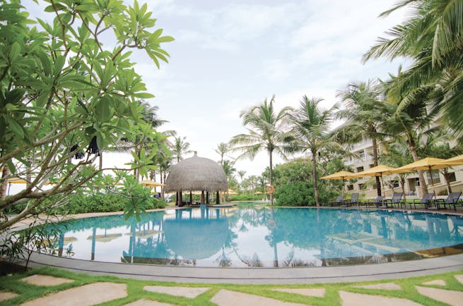 Heritance Negombo Sri Lanka pool umbrellas sun loungers trees hotel in background