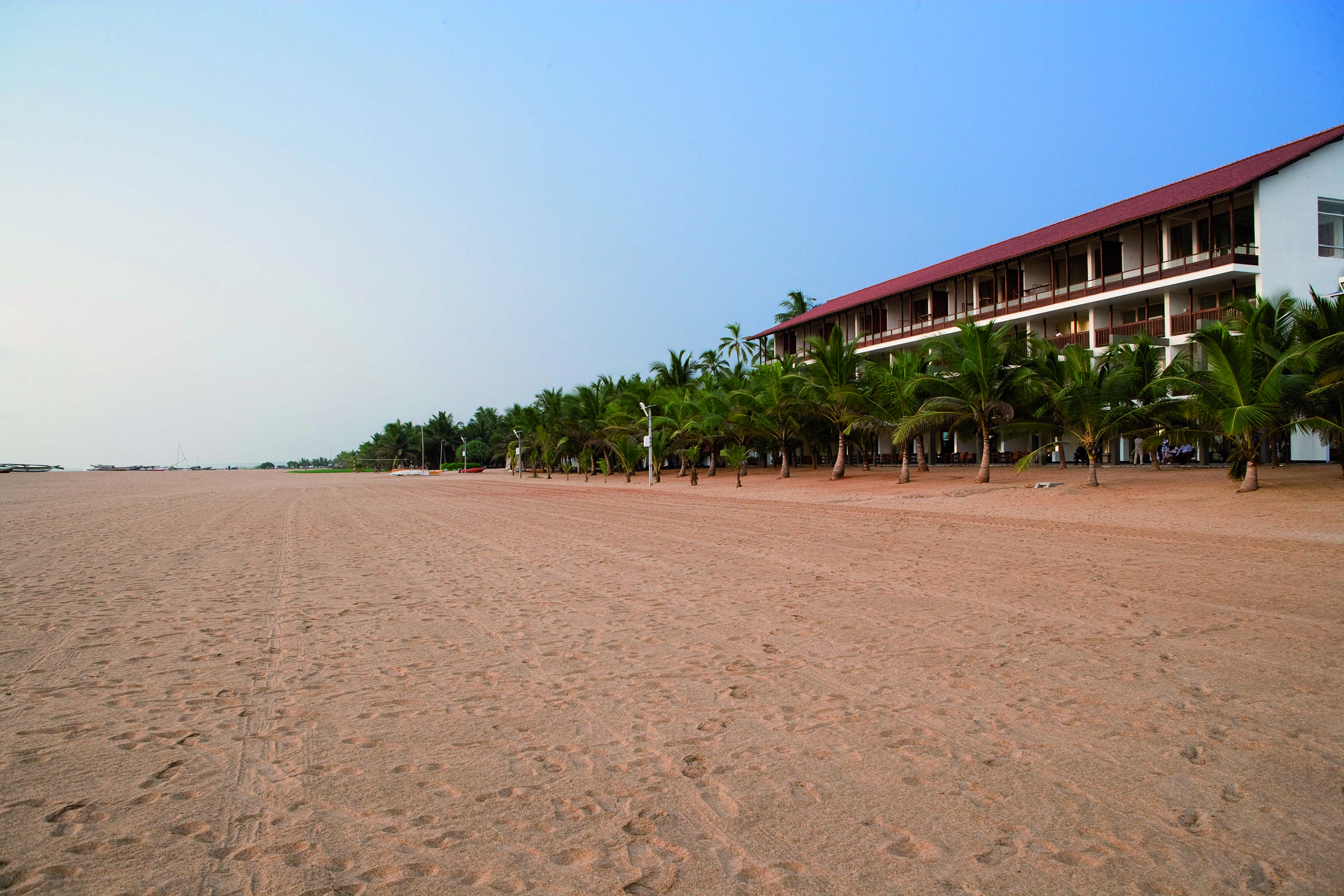 Jetwing Blue Sri Lanka beach long sandy beach palm trees hotel building