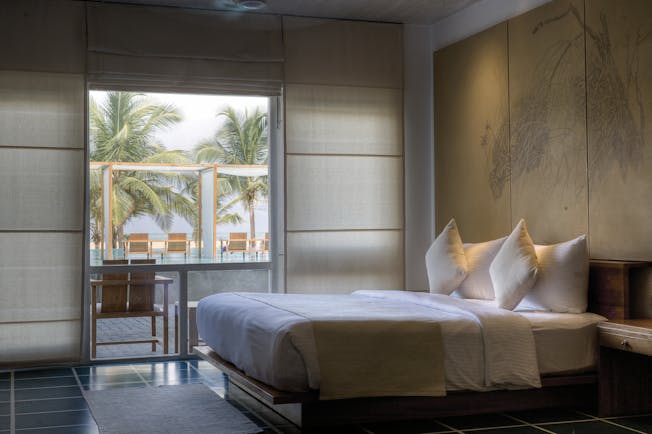Jetwing Blue Sri Lanka deluxe room bed window overlooking pool modern décor