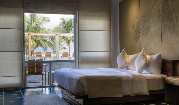 Jetwing Blue Sri Lanka deluxe room bed window overlooking pool modern décor