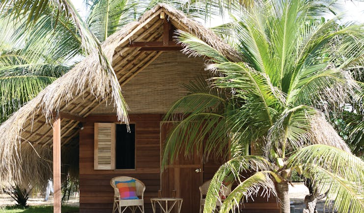 Palagama Beach garden cabana exterior, thatched rood, terrace with chair, surrounded by palm trees