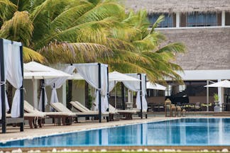 Anilana Pasikuda pool, infinity pool overlooking sea, beach cabanas, palm trees, lawn