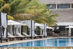 Anilana Pasikuda pool, infinity pool overlooking sea, beach cabanas, palm trees, lawn